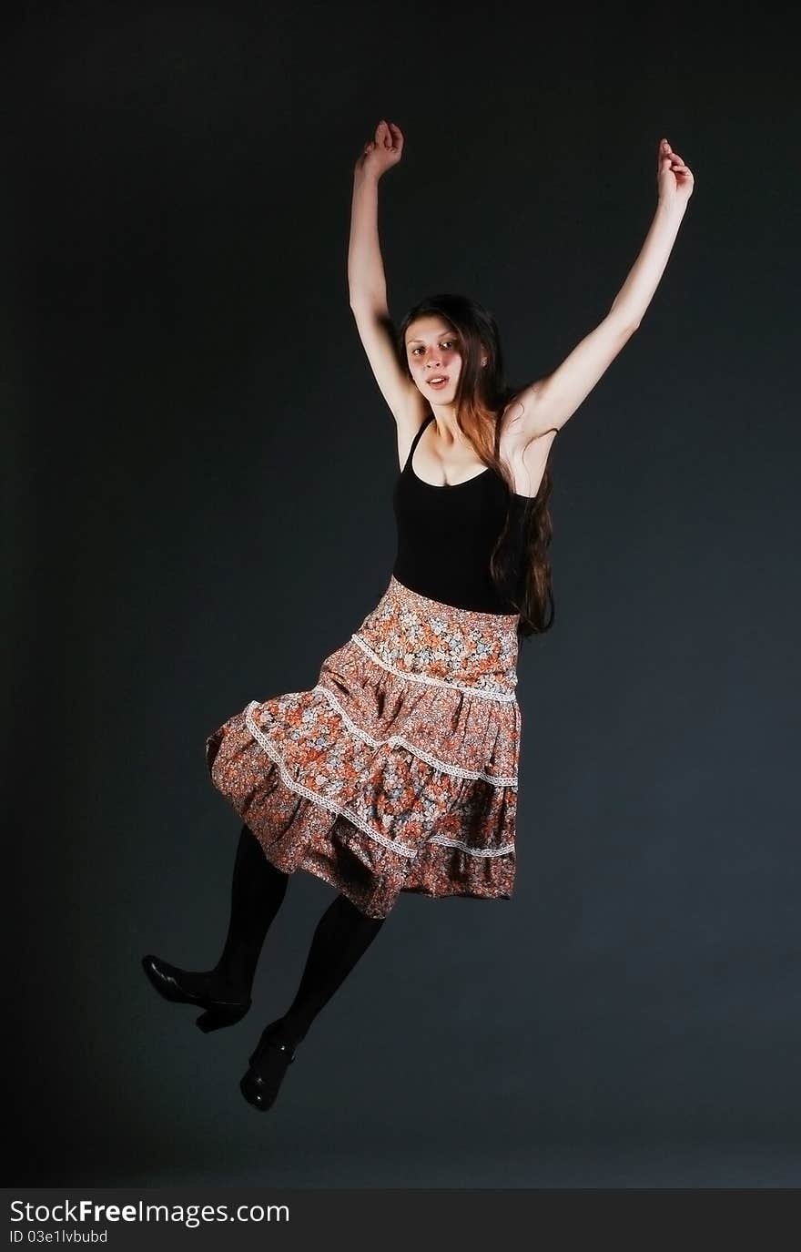 Dancing girl with colored skirt jumping