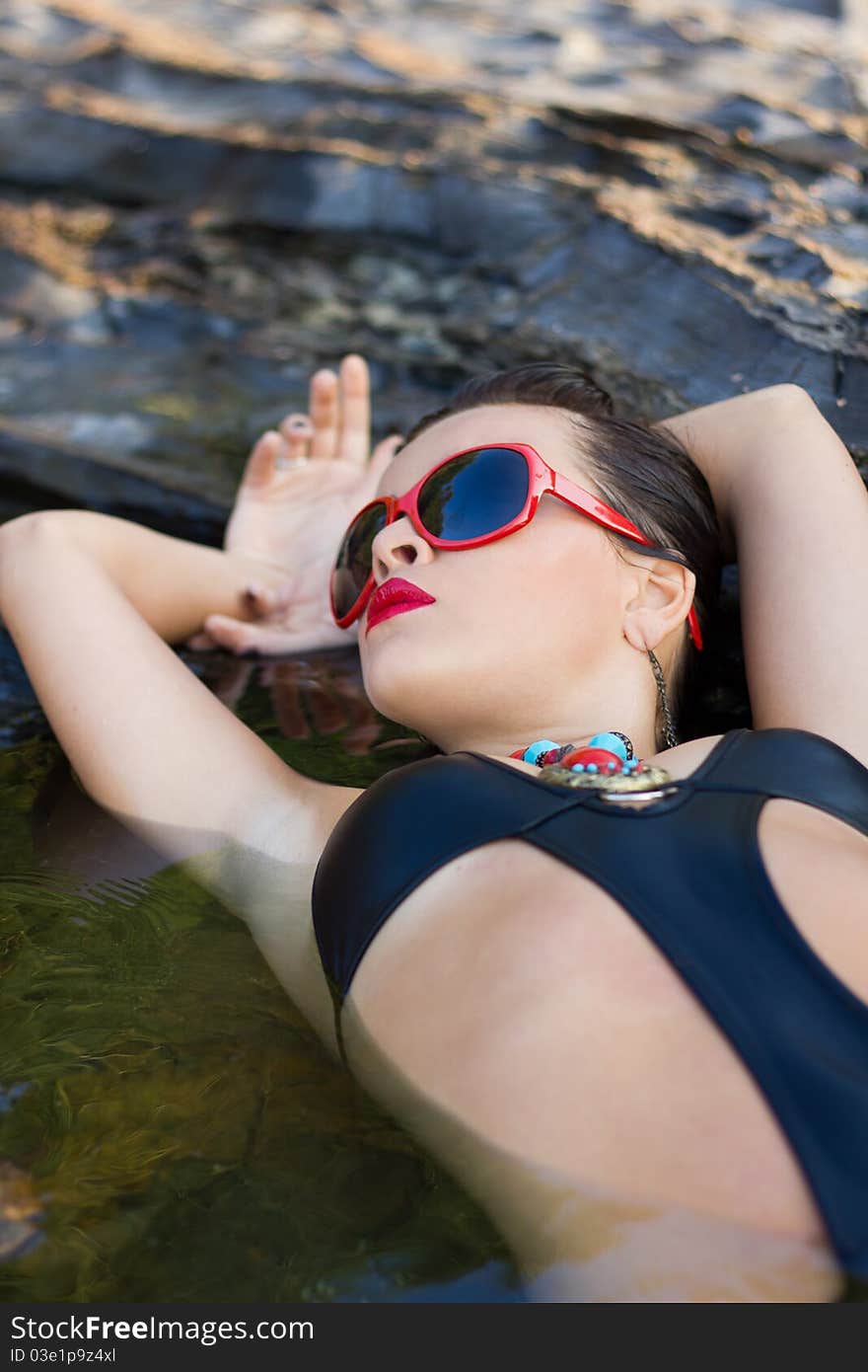 Overhead portrait of attractive young woman with makeup relaxing in sea or rock pool. Overhead portrait of attractive young woman with makeup relaxing in sea or rock pool.