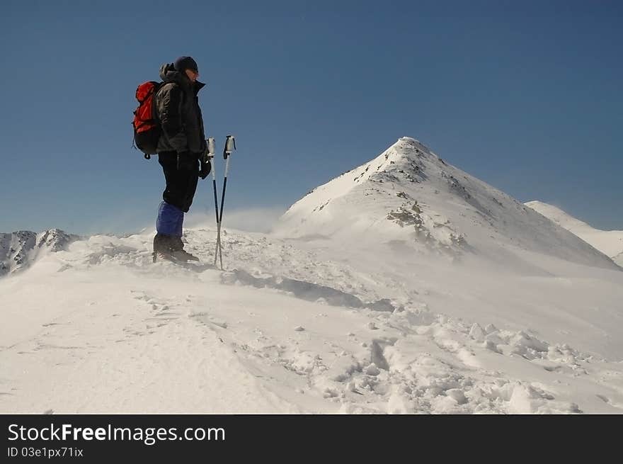 Climber facing wind during trekking on top of Retezat Mountains, Romania. Climber facing wind during trekking on top of Retezat Mountains, Romania