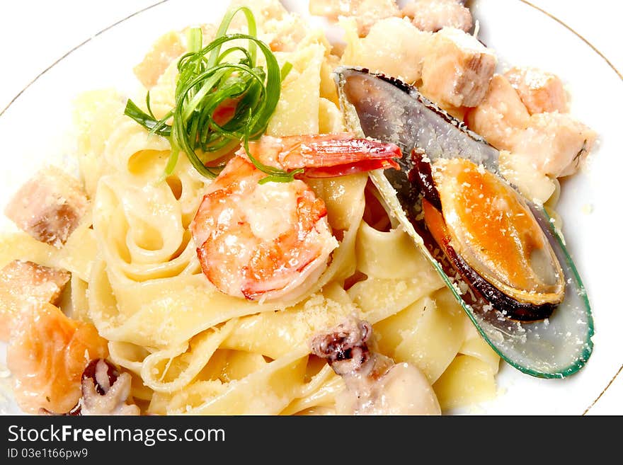 Spaghetti on a plate with cheese parmesan, sauce and seafood