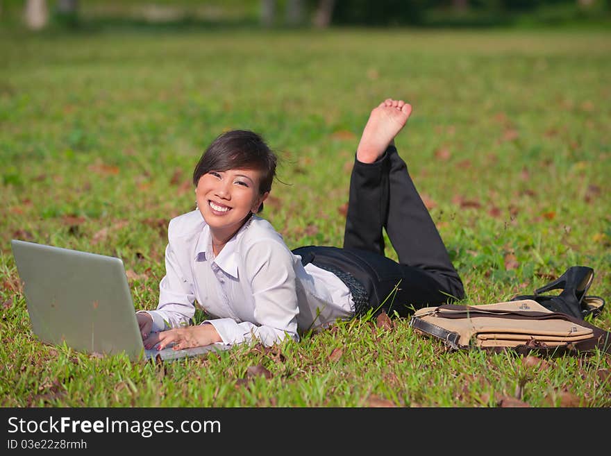 Business woman staying connected while out in the park. Business woman staying connected while out in the park