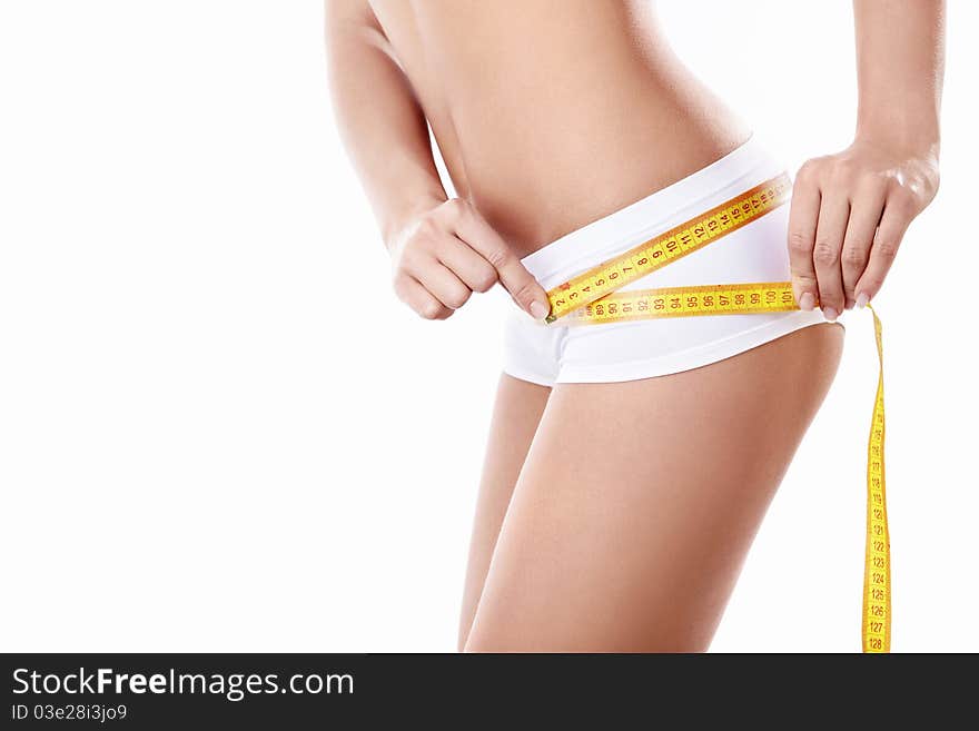 Young girl measuring hip on a white background. Young girl measuring hip on a white background