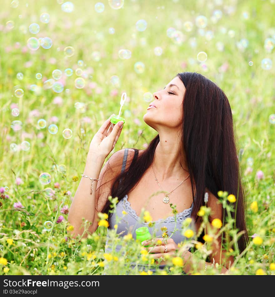 Happy woman smile in green grass soap bubbles around. Happy woman smile in green grass soap bubbles around