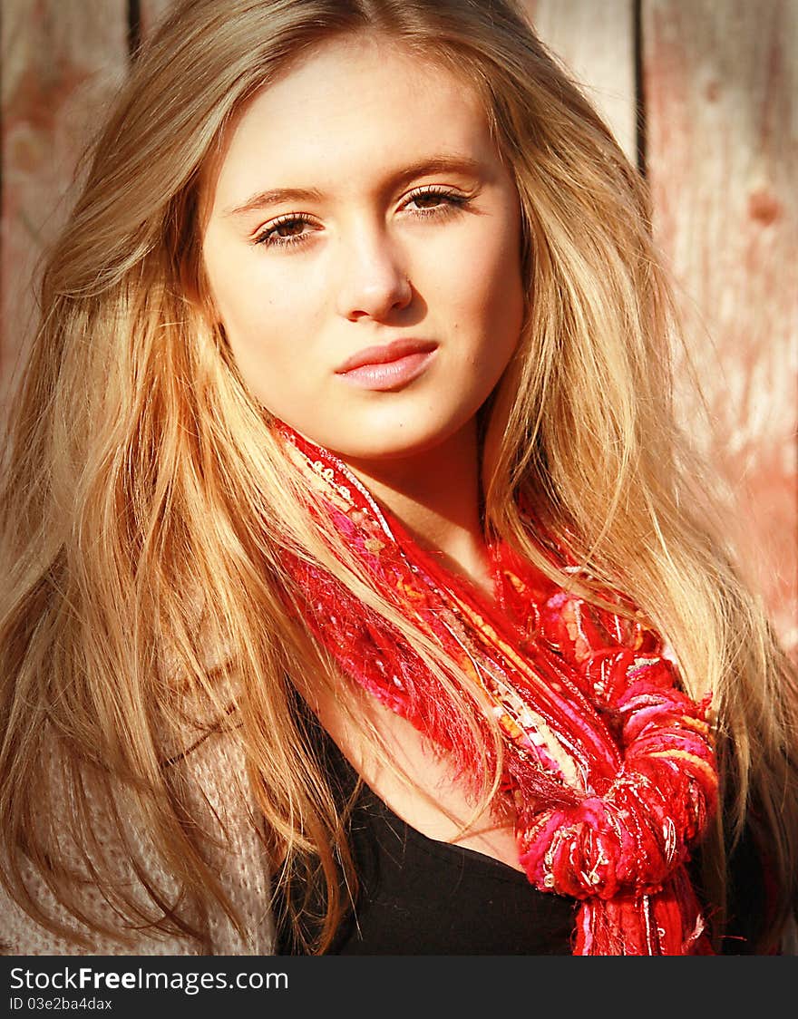 A girl/woman with a red scarf and brown eyes looking relaxed in the warm sunshine. A girl/woman with a red scarf and brown eyes looking relaxed in the warm sunshine