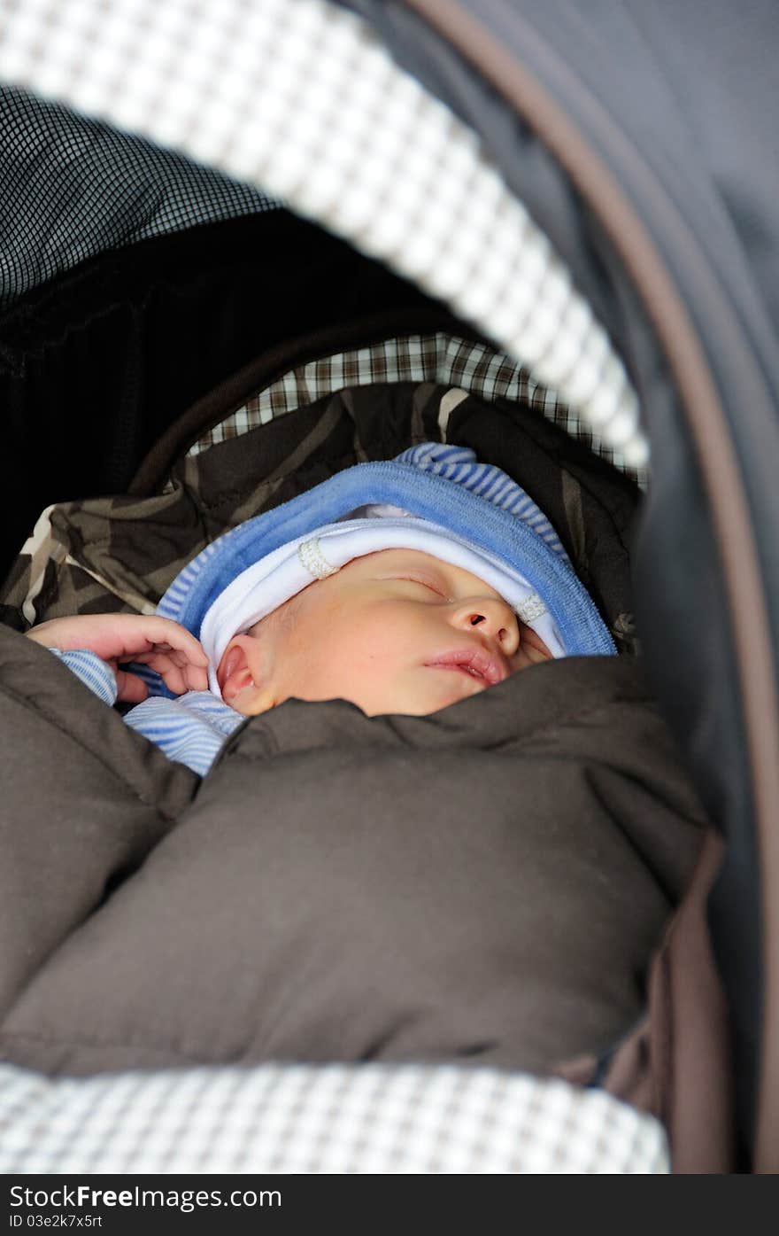 Cute new born baby sleeping in his buggy. Cute new born baby sleeping in his buggy.