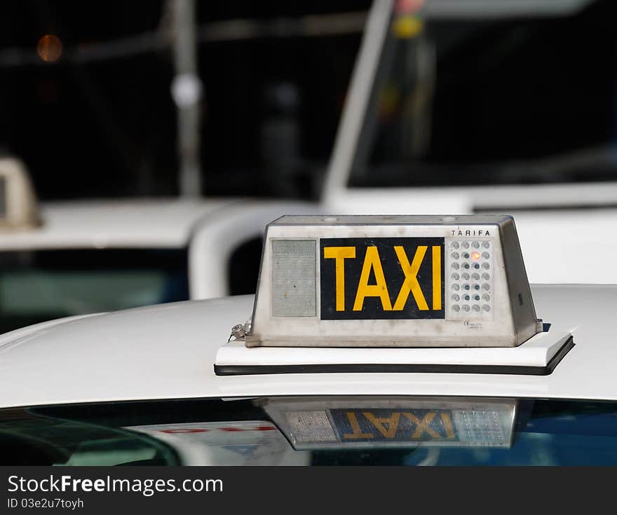 Yellow taxi sign on a roof of taxi car waiting in a queue.