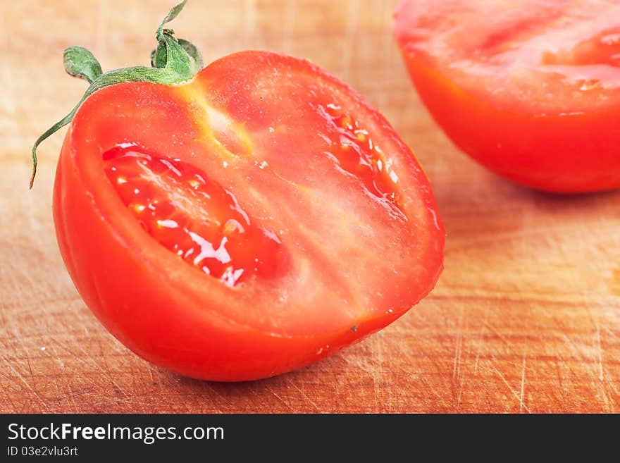 Closeup view of single tomato on a wood board