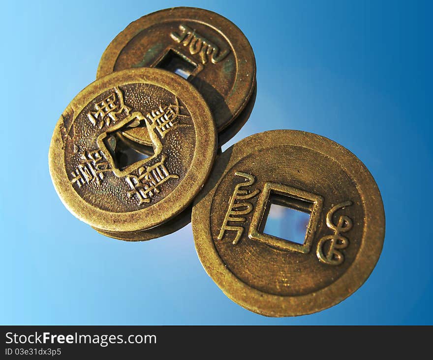 Three shining chinese luck coins from 18. Century on a mirror. Three shining chinese luck coins from 18. Century on a mirror