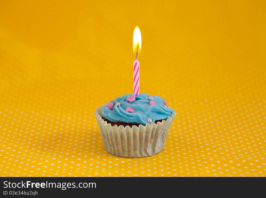 Birthday cupcake with candles on a yellow background. Birthday cupcake with candles on a yellow background