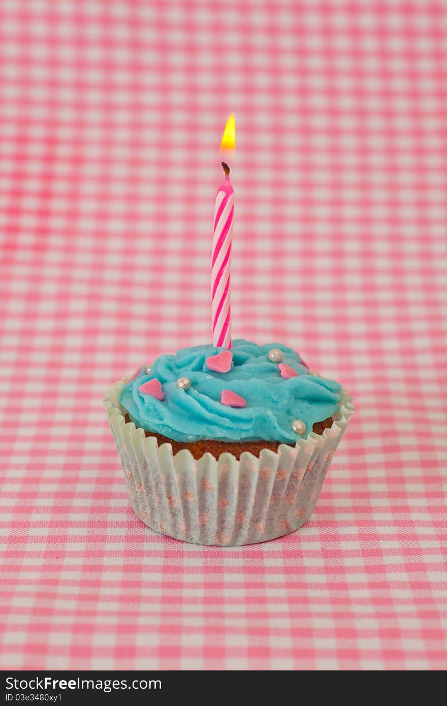 Birthday cupcake with candles on a yellow background. Birthday cupcake with candles on a yellow background