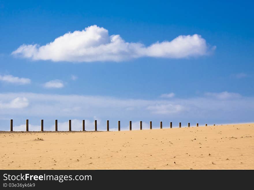 Wooden fence dissapearing into the infinity of the dessert.