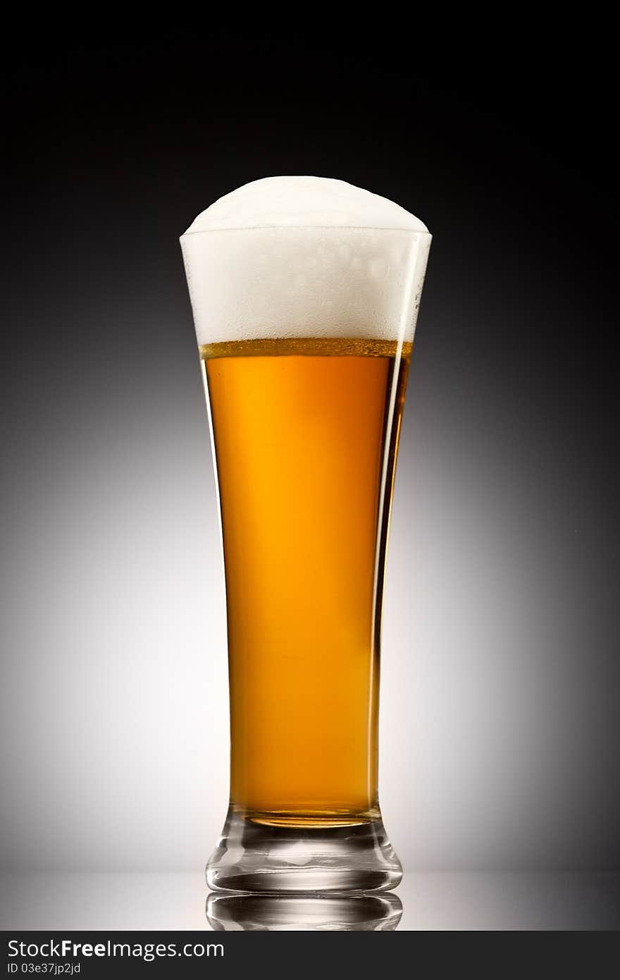 Beer into glass on a gray