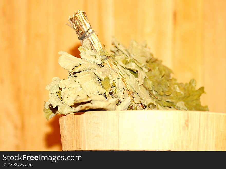 Oak broom in a basin on a background bath. Oak broom in a basin on a background bath