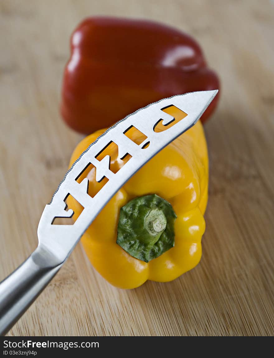 Sweet red and yellow peppers with a knife