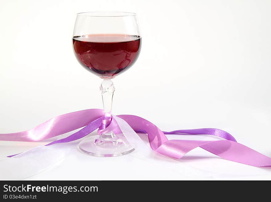 Glass of wine with decorative ribbons on white background. Glass of wine with decorative ribbons on white background