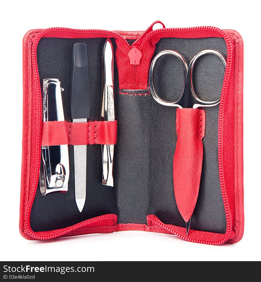 Small traveler's nail care kit of necessary instruments (scissors, tweezers, nail file and trimmer) in red leather pocket case, isolated on white background