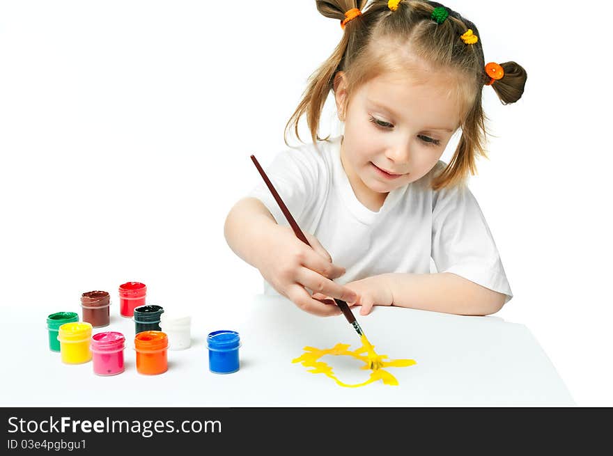 Cute little girl with a brush and paints