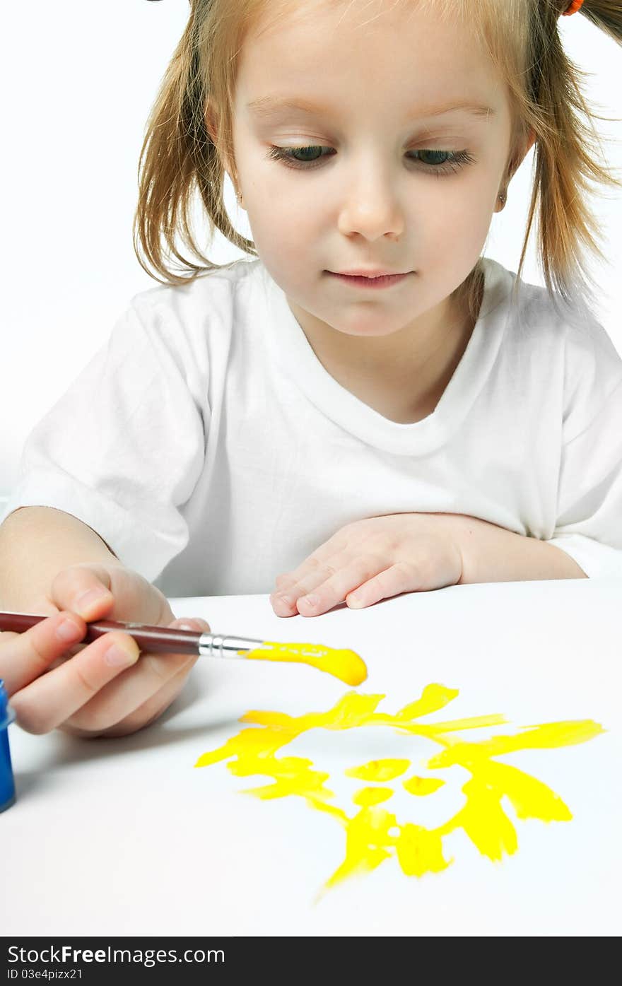 Cute little girl with a brush and paints