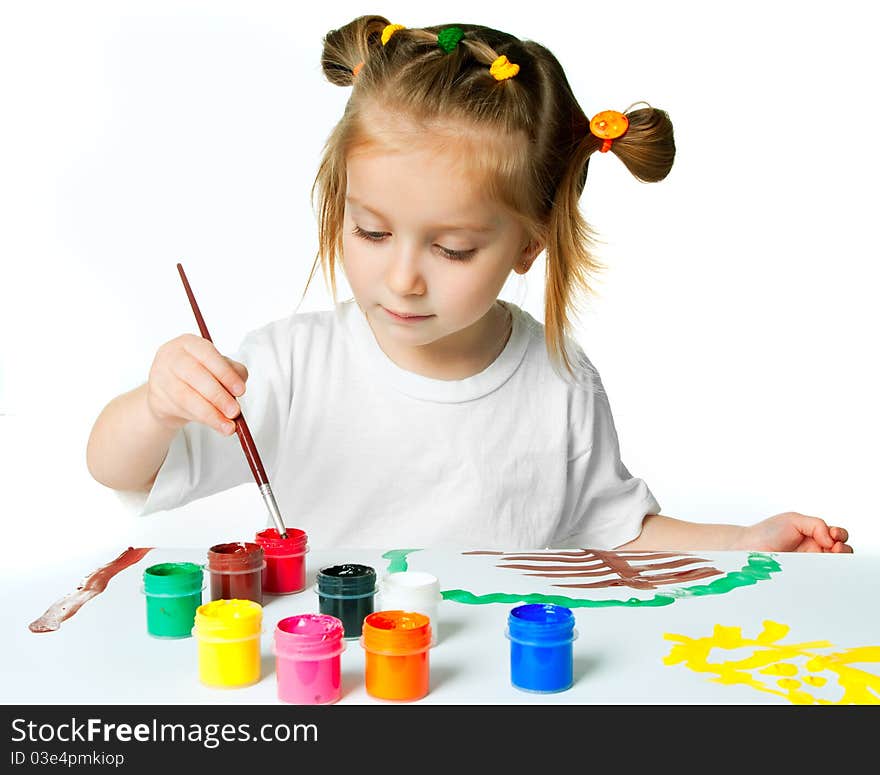 Cute little girl with a brush and paints