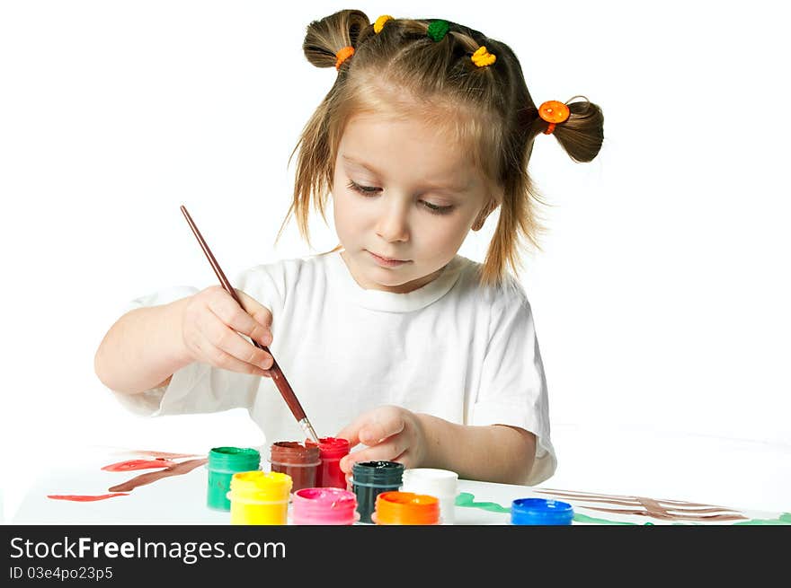 Cute little girl with a brush and paints