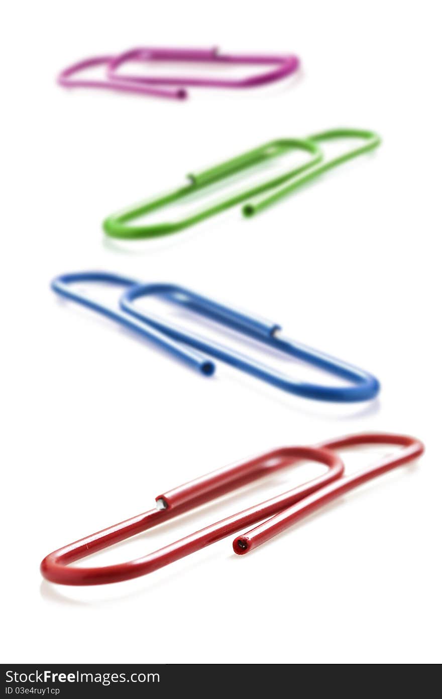 Colorful paper clips on a white background with space for text