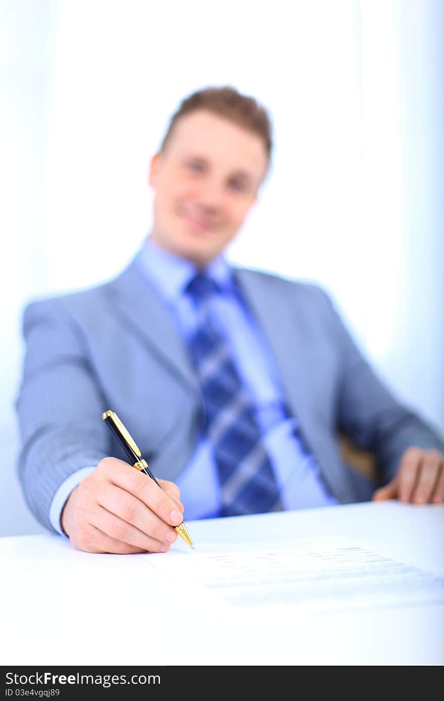 Full length of a handsome business man with hands folded against white background