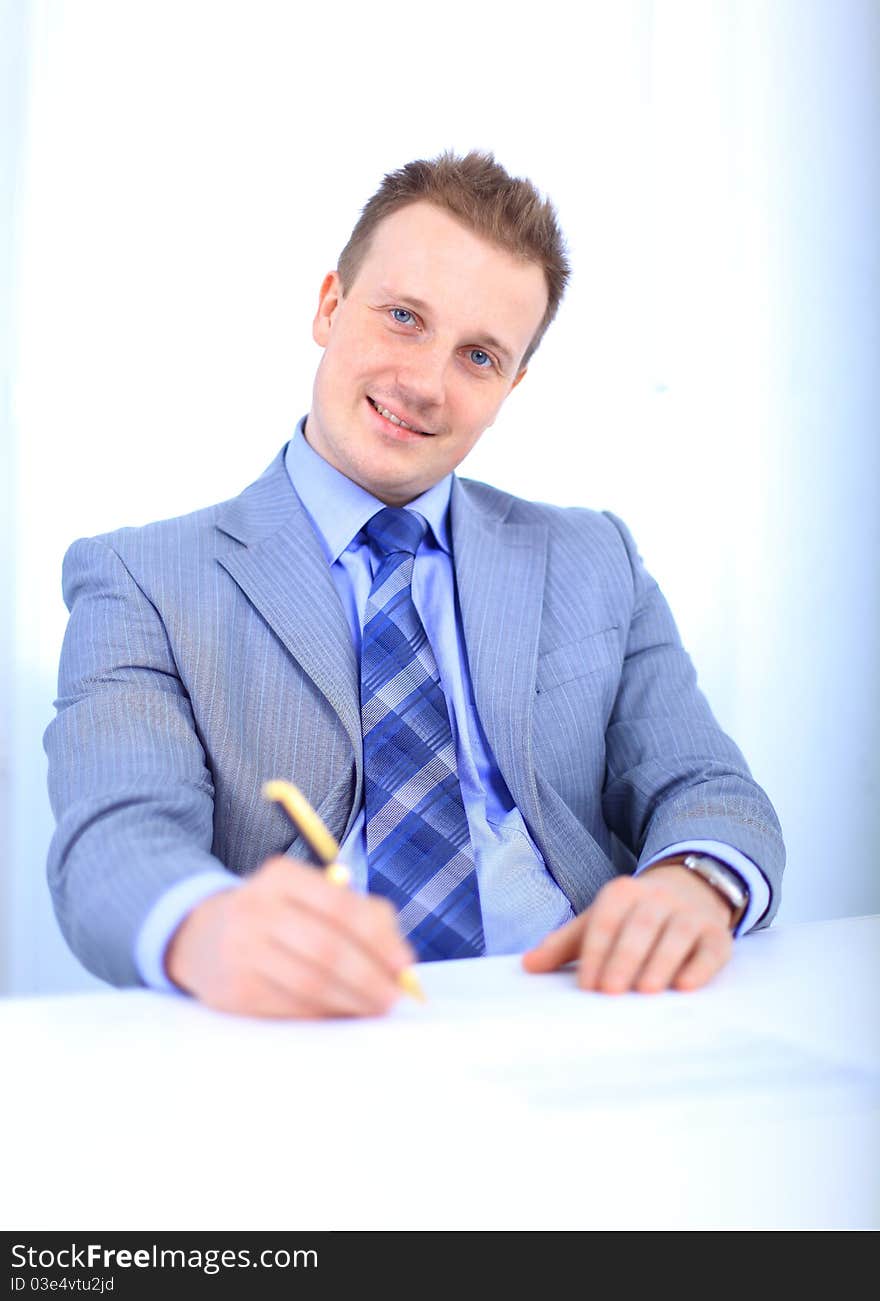 Full length of a handsome business man with hands folded against white background