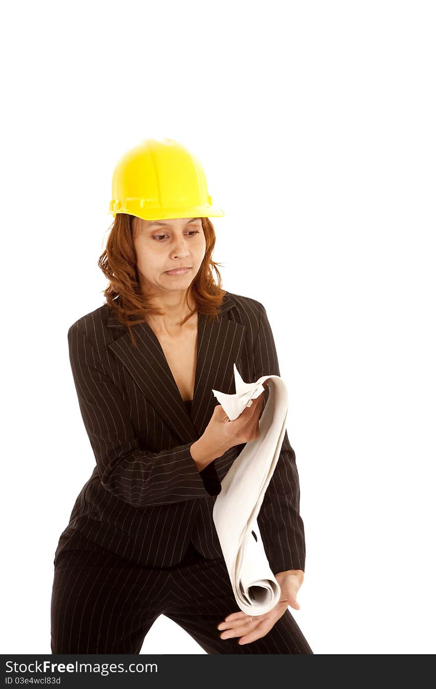 A woman is in a yellow hard hat about to drop some plans. A woman is in a yellow hard hat about to drop some plans.