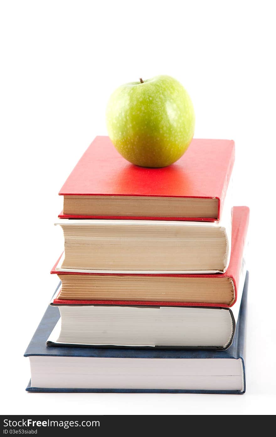 Pile of books and apple isolated on white. Pile of books and apple isolated on white