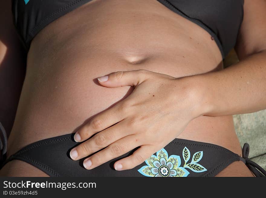 Pregnant woman in bikini sunbathing