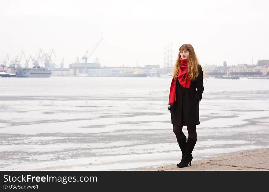 Thoughtful beautiful girl with red hair in the red scarf and black coat. Thoughtful beautiful girl with red hair in the red scarf and black coat