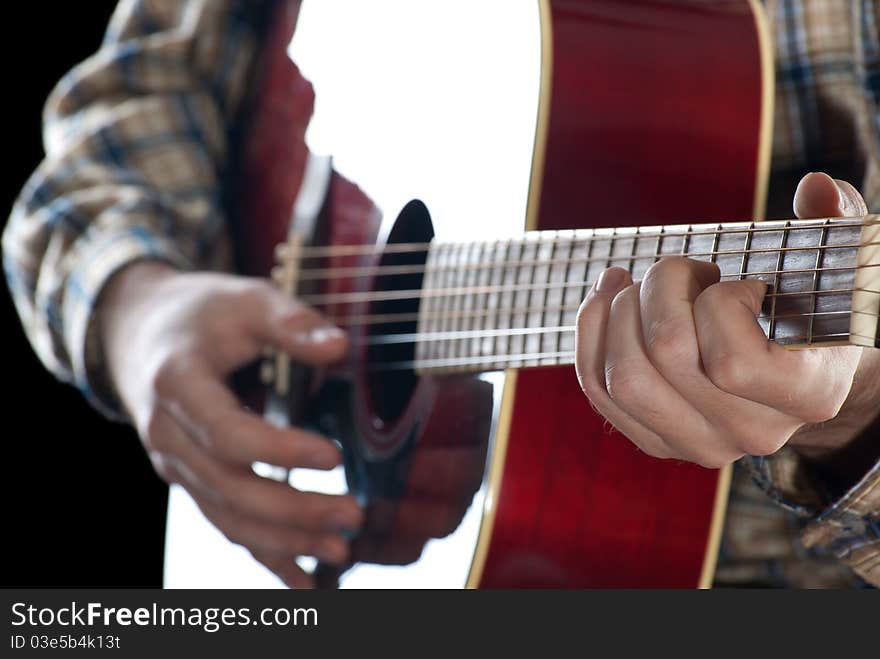 Closeup. Man playing guitar on black background.