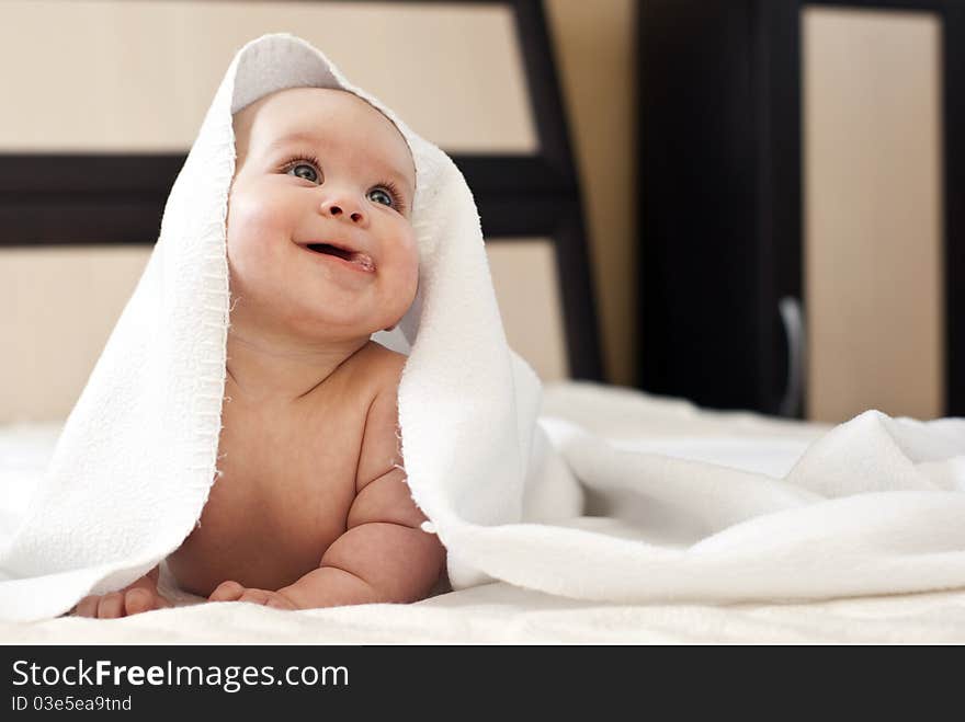 Happy smiling baby girl on bed after bath. Happy smiling baby girl on bed after bath.