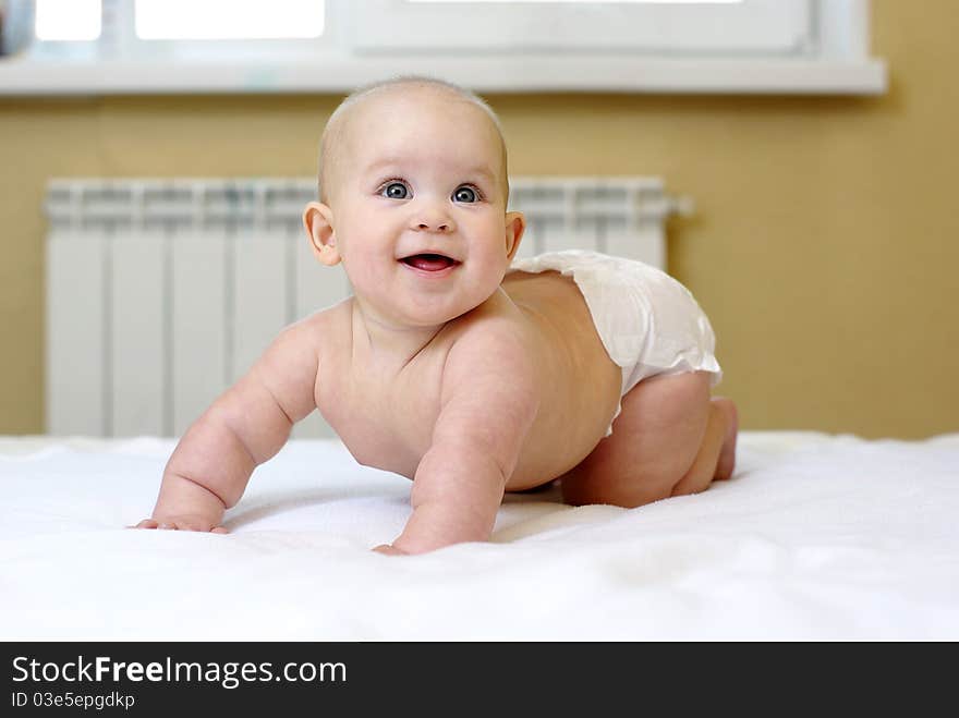 Small smiling baby on bed.