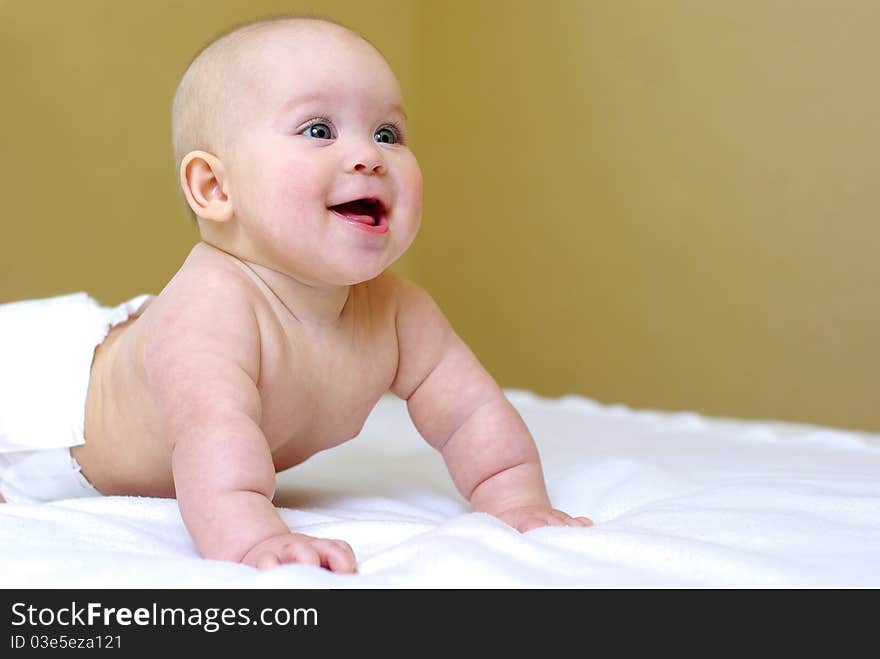 Happy smiling baby girl on bed. Happy smiling baby girl on bed.