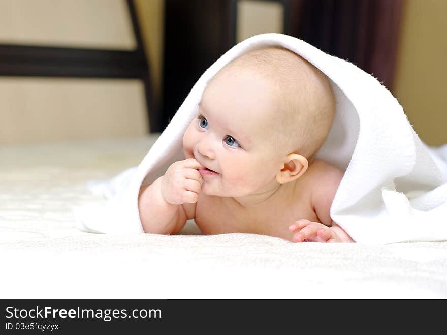 Happy smiling baby girl on bed after bath. Happy smiling baby girl on bed after bath.