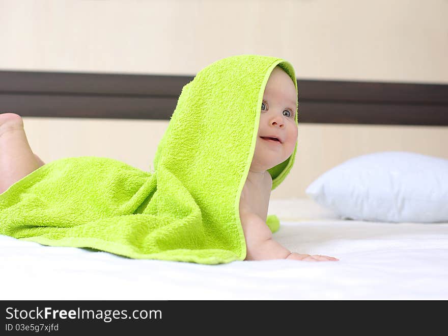 Happy smiling baby girl on bed after bath. Happy smiling baby girl on bed after bath.