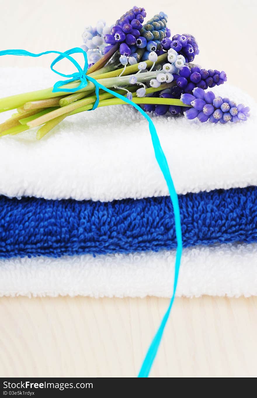 Tower of white and blue towels with bouquets muscari. Tower of white and blue towels with bouquets muscari