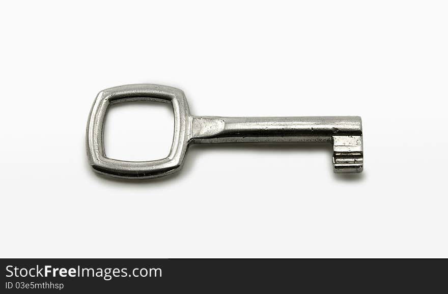 Metallic key on white background