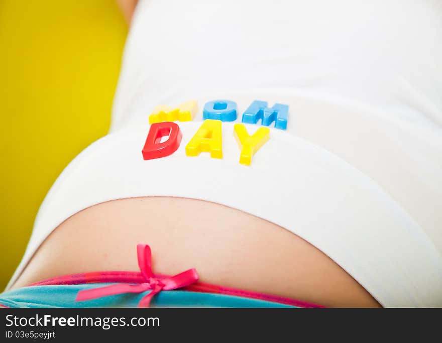 Pregnant woman belly with baby clothes