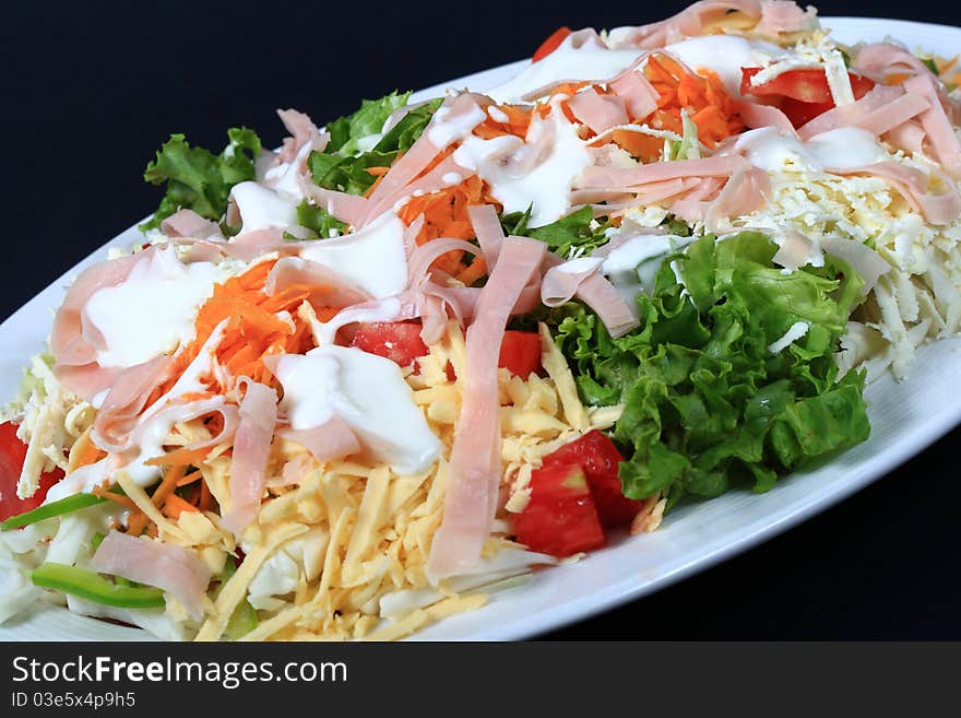 Fresh salad from vegetables, ham and cheese