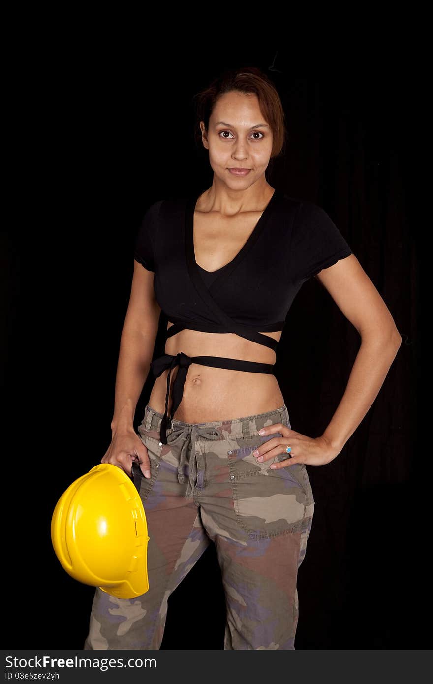 A woman is smiling and holding a hard hat on a black background. A woman is smiling and holding a hard hat on a black background.