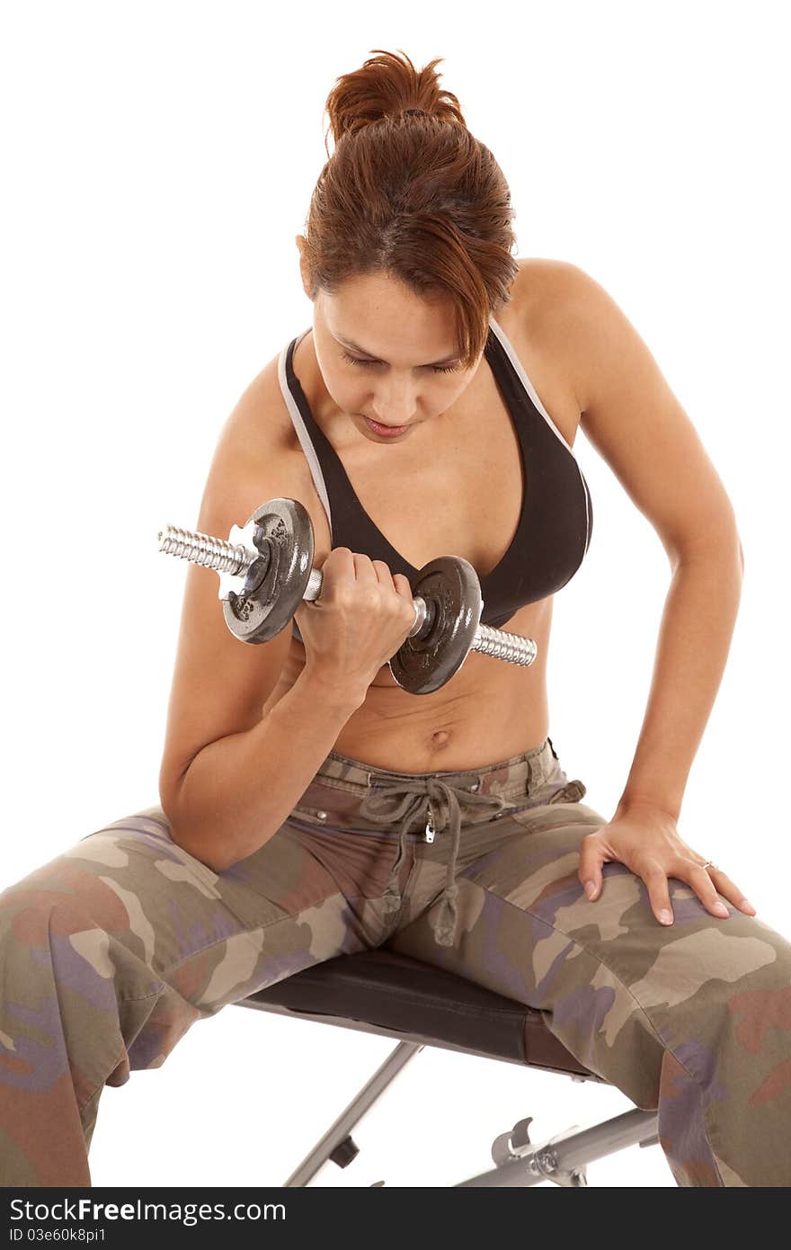 A woman is working out with some weights looking determined.