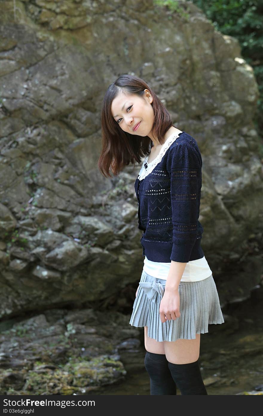 Young japanese woman standing on the rock