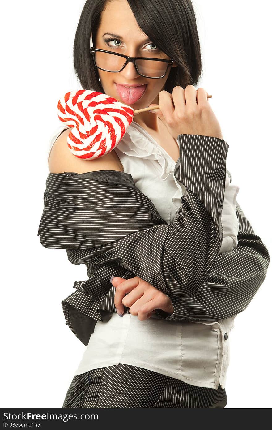 Young sexy woman in business suit licking heart shaped lollipop. Young sexy woman in business suit licking heart shaped lollipop.