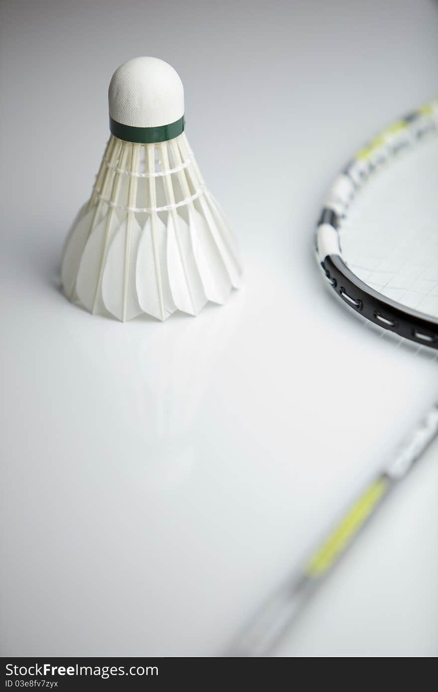 Badminton shuttlecock and racket on white background (shallow DOF; color toned image)