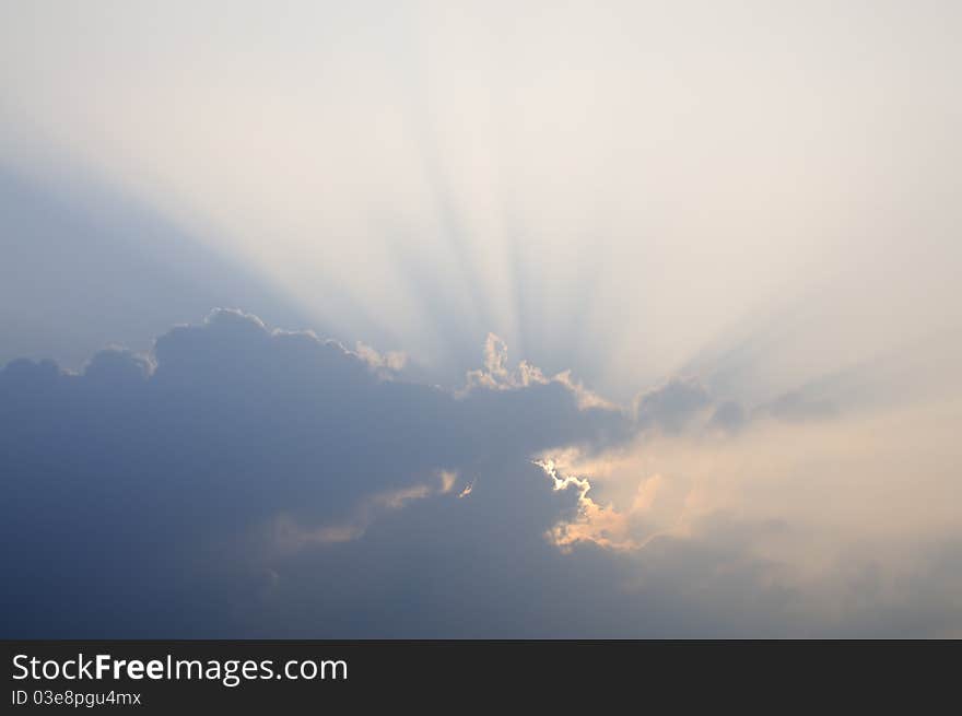 A sunburst shining through the clouds. A sunburst shining through the clouds