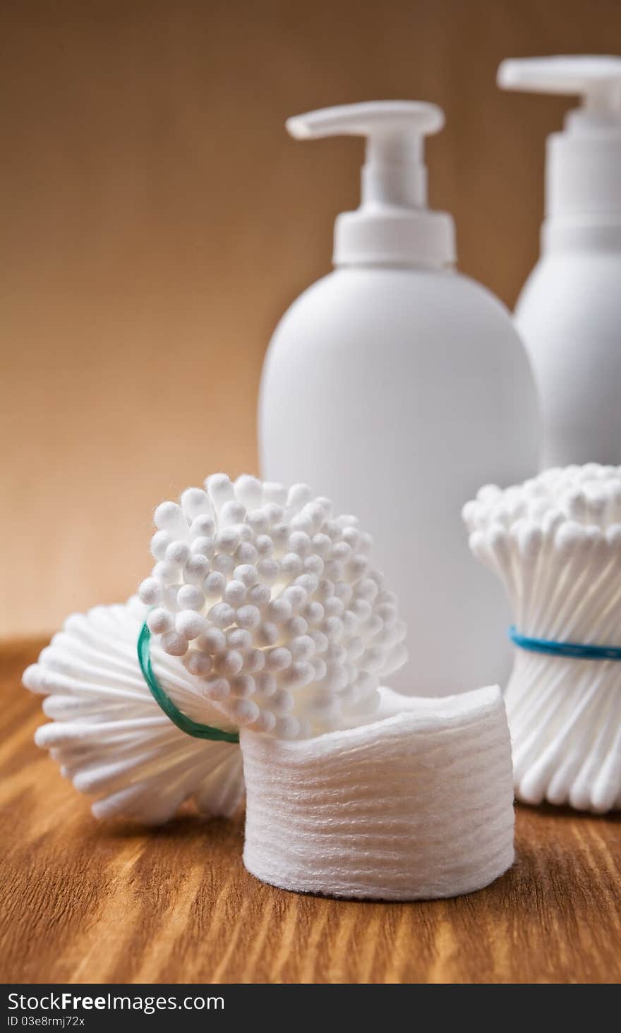 Studio shot cotton swabs and pads with spray bottles on wooden board. Studio shot cotton swabs and pads with spray bottles on wooden board