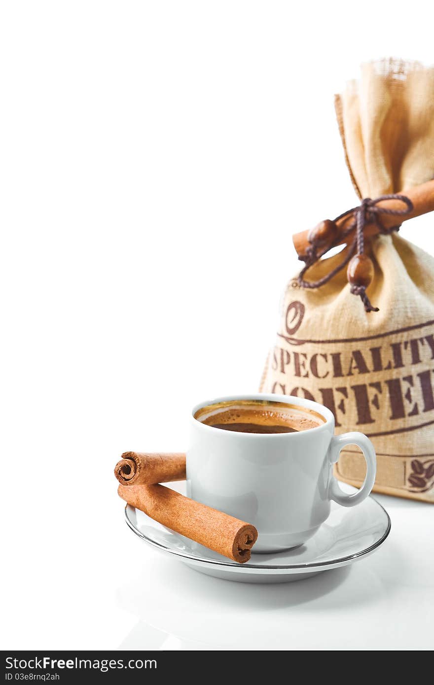 Bright composition of coffee cup and coffee sack with cinnamon stick on white background. Bright composition of coffee cup and coffee sack with cinnamon stick on white background