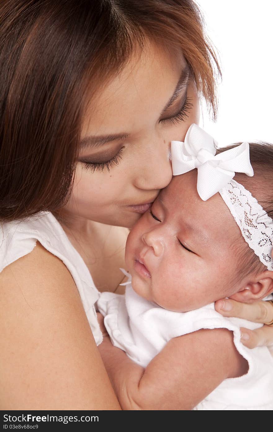 A close up of a baby and her mother's faces they are showing the expression of peace on their faces. A close up of a baby and her mother's faces they are showing the expression of peace on their faces.